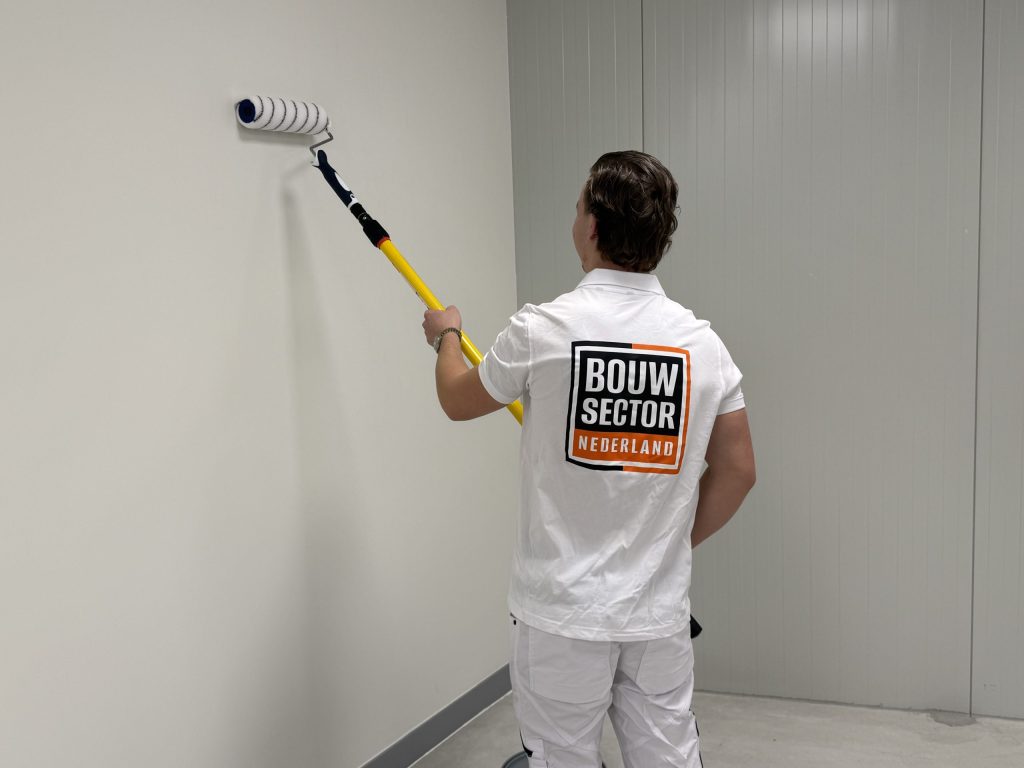 Schilder van Bouwsector Nederland aan het werk aan een wand